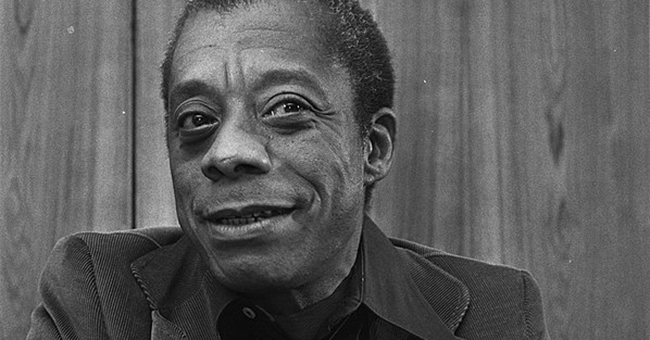 A photo of James Baldwin, smiling.